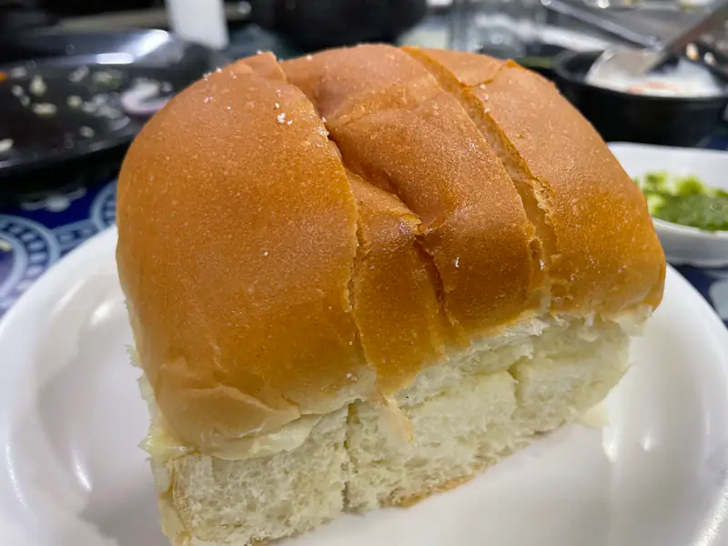 A soft bun maska, sliced and buttered