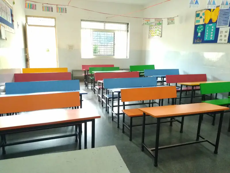 Bright classroom with colourful desks and benches