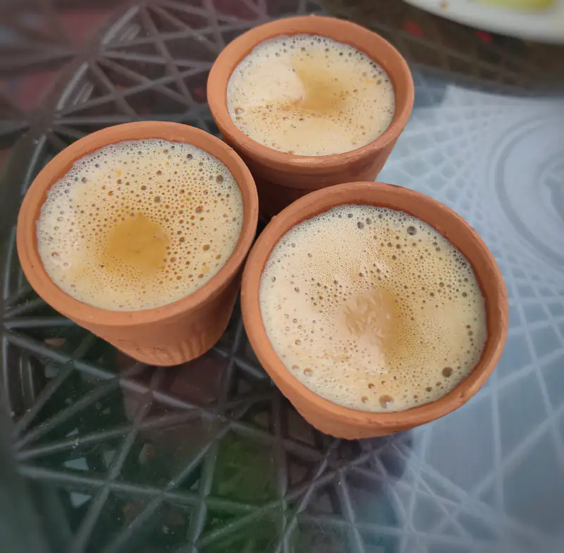 Three clay kulhads of frothy chai